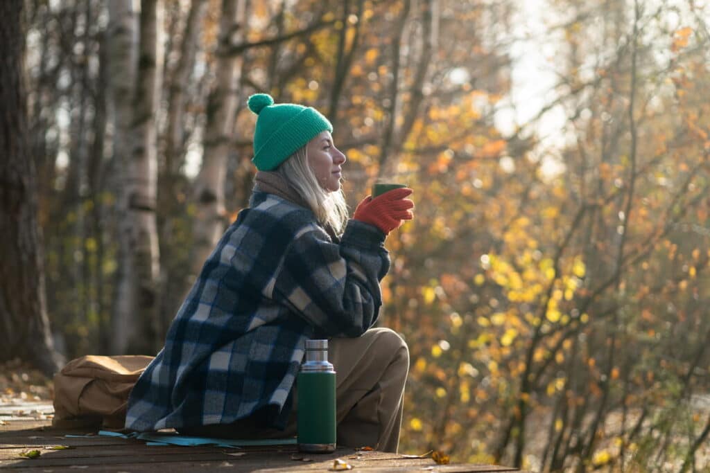 lady enjoying hot drink in forest on a Digital Detox Package
